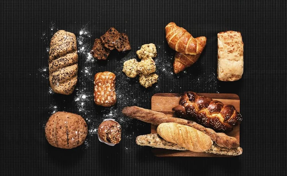 Pieczywo i ciastka rozłożone na ciemnym blacie